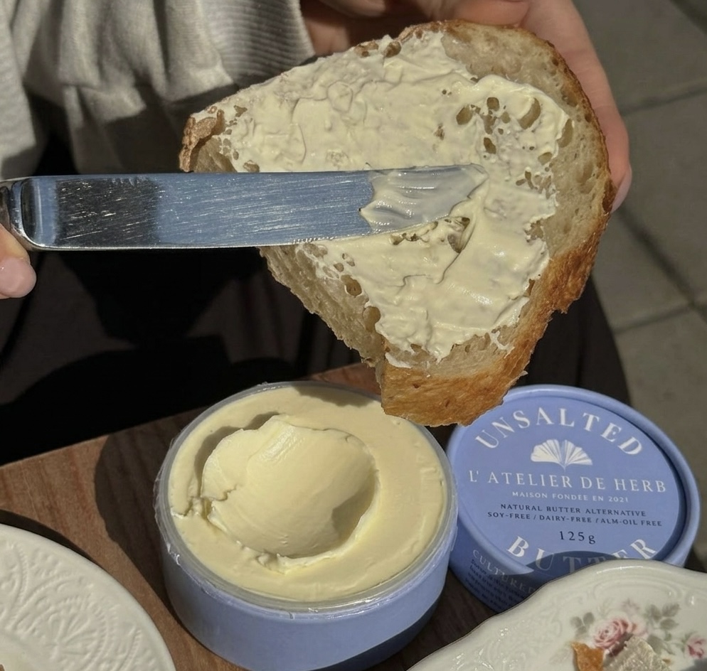VG Saveur butter spread on bread beside the product tub.